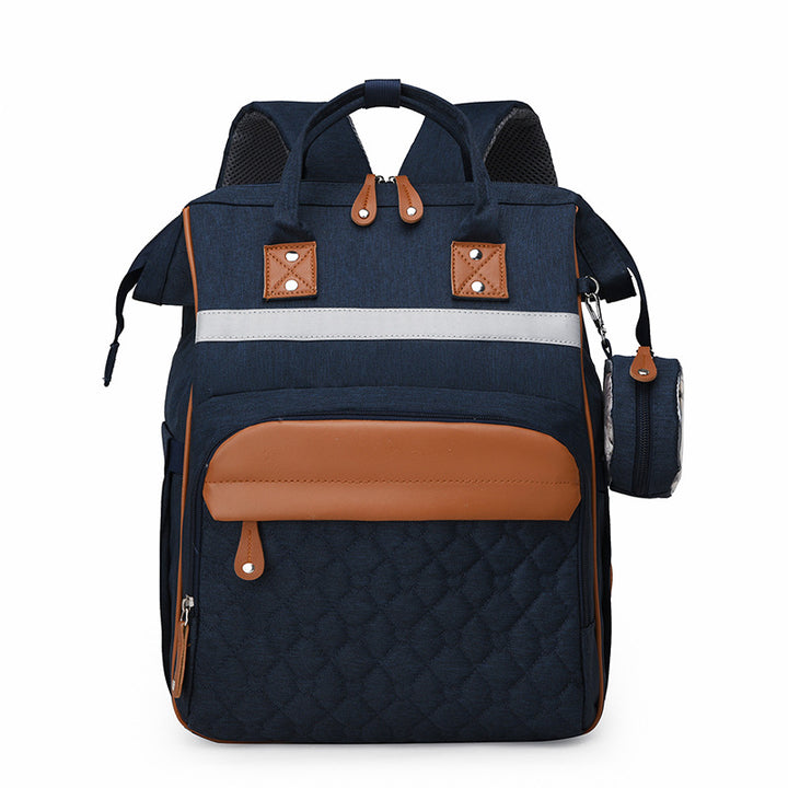 Sac à dos à langer matelassé bleu marine bandes cuir caramel