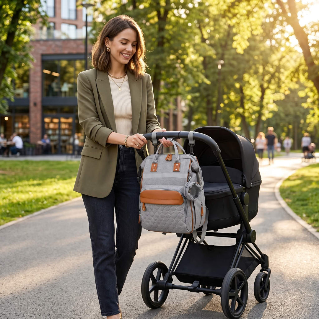 Maman avec son sac à dos à langer bandes cuir caramel accroché à la poussette