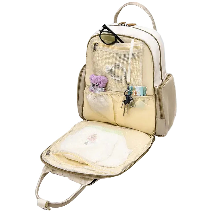 Intérieur du sac à dos à langer 2 pièces Maison Lunö — compartiment principal ouvert, poche filet et rangements pour couches et lingettes